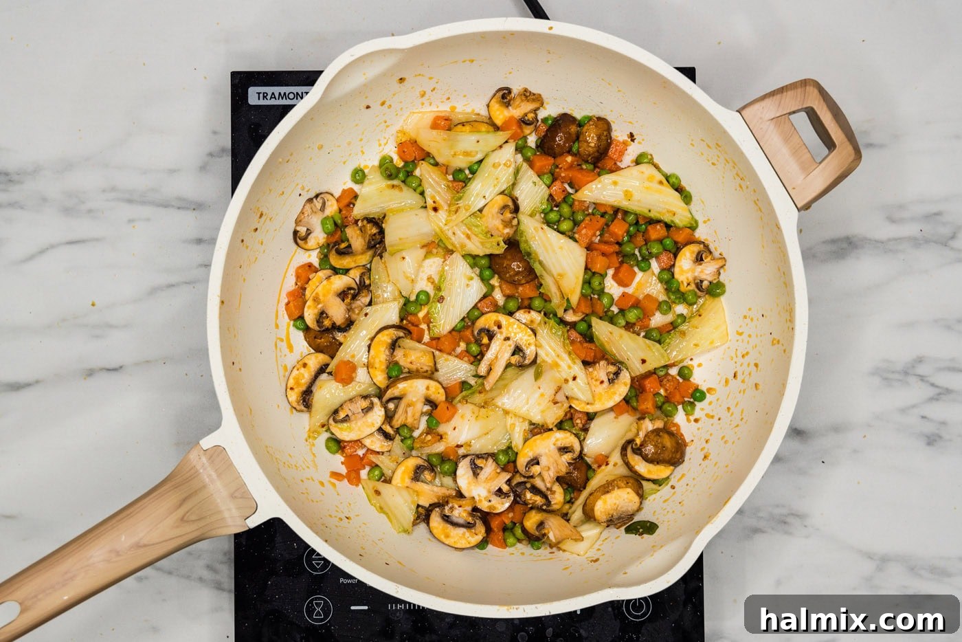 Vibrant stir-fried cabbage, carrots, and peas cooking in a skillet
