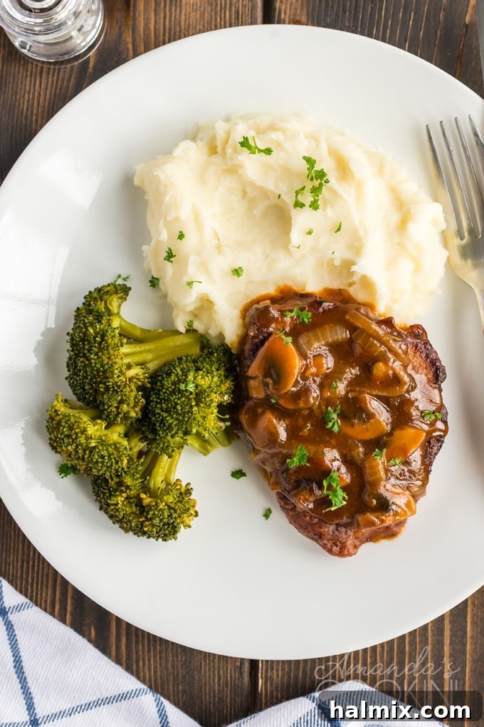 A plate of savory Oven Swiss Steak served alongside steamed broccoli for a balanced meal