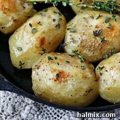 A close up photo of roast potatoes in a cast iron skillet.