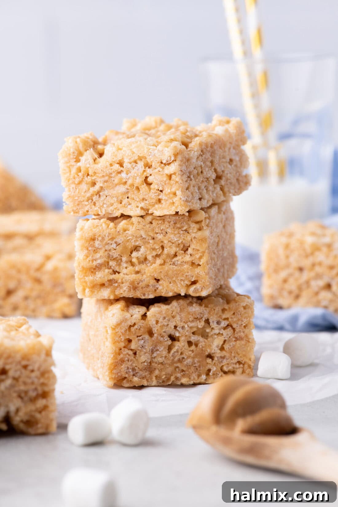 Peanut Butter Crunch Bars 2 Stack of three homemade Peanut Butter Rice Krispie Treats, showcasing their chewy texture and golden-brown hue, ready to be enjoyed.