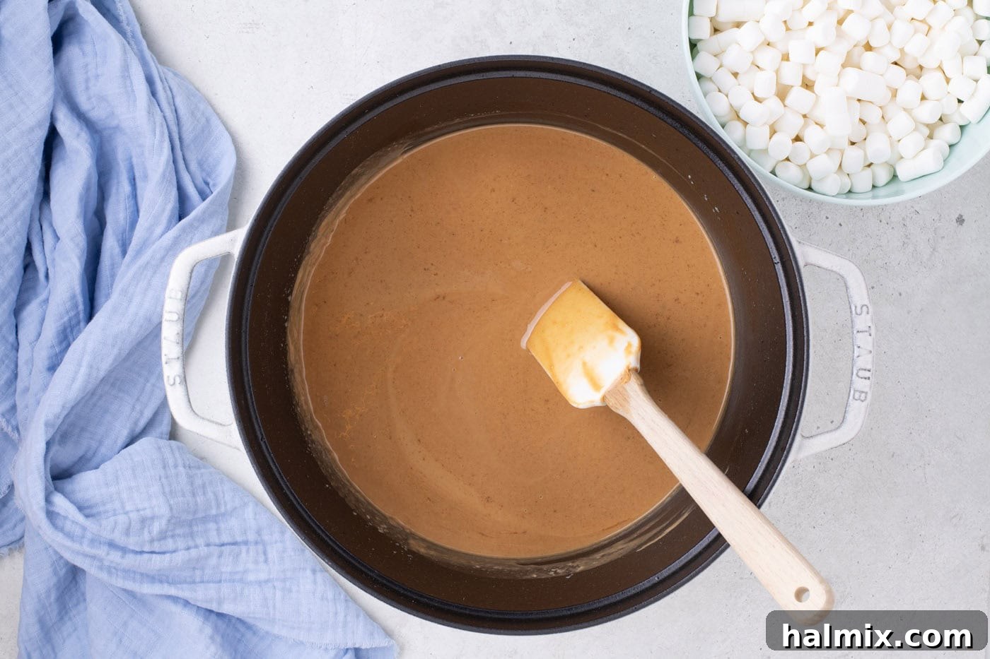 Peanut Butter Crunch Bars 6 Creamy peanut butter and vanilla extract being stirred into the melted butter in a pot with a rubber spatula, until the mixture is smooth.