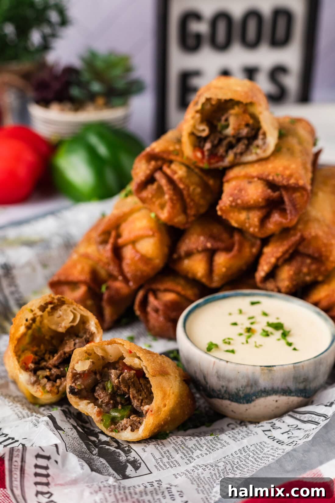 Stack of Philly Cheesesteak Egg Rolls with one cut in half