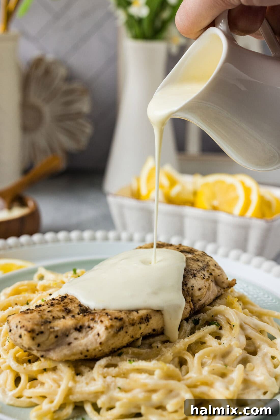 Zesty Lemon Cream Sauce 2 Lemon Cream Sauce being poured over a succulent chicken breast, enhancing its appeal with a vibrant, glossy finish.