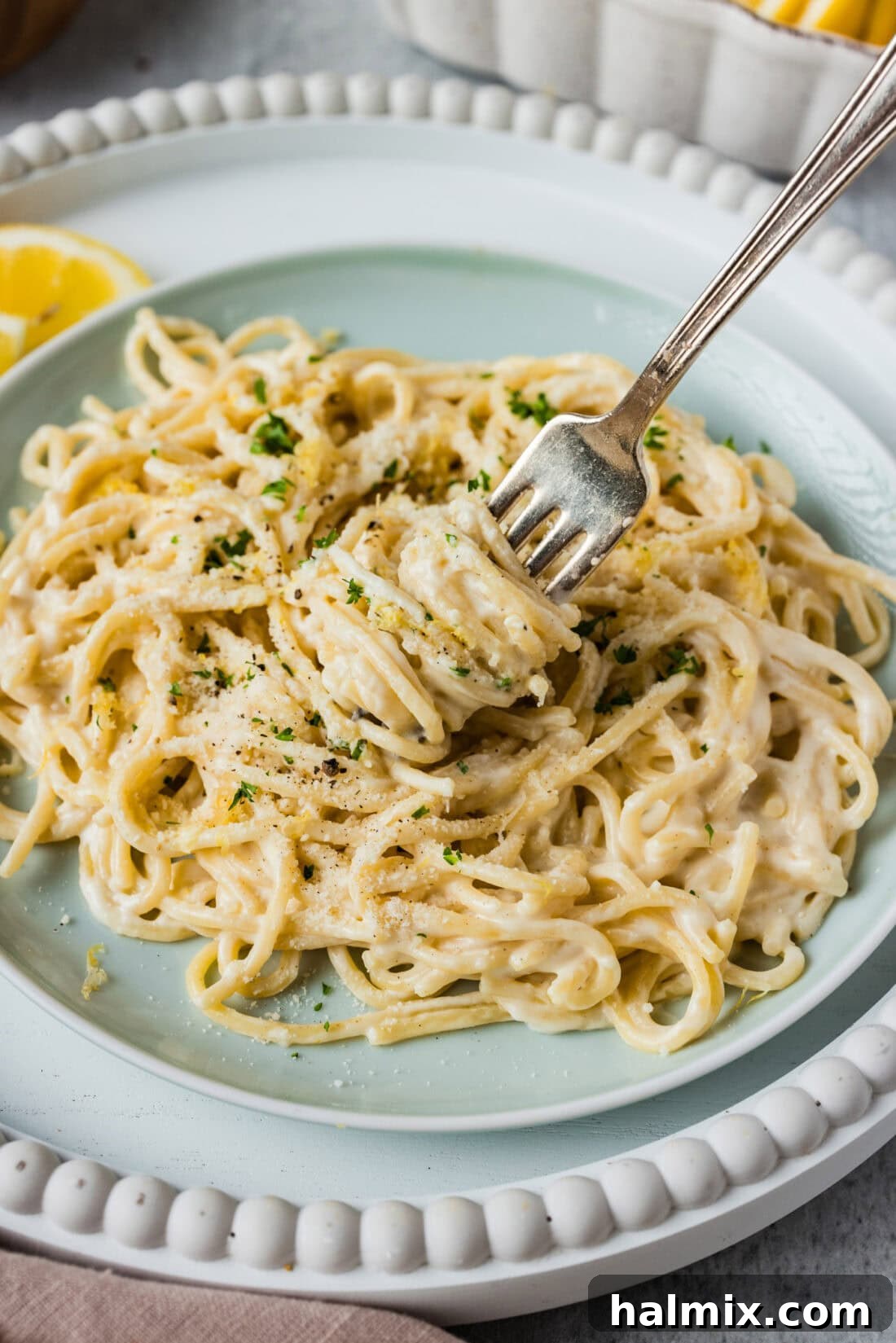 Zesty Lemon Cream Sauce 3 Perfectly cooked pasta twirled around a fork, showcasing its readiness to be coated in a luscious lemon cream sauce.