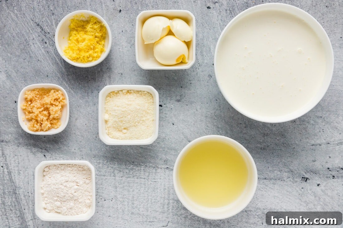 Zesty Lemon Cream Sauce 4 A collection of fresh ingredients neatly arranged for making Lemon Cream Sauce, including lemons, garlic, butter, and cream.