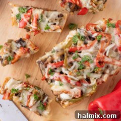 Slices of Philly Cheesesteak Cheesy Bread on a wooden cutting board
