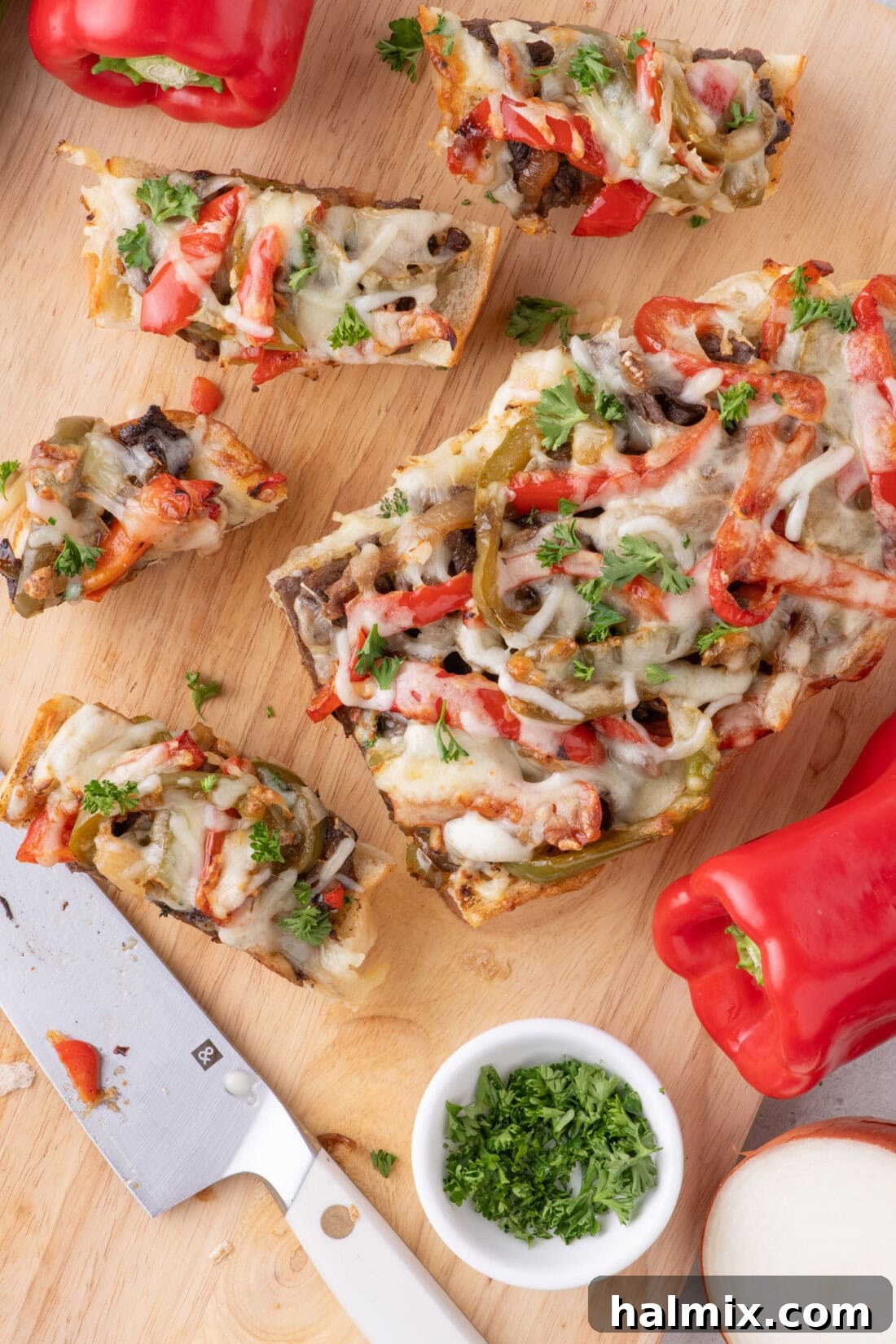 Philly Cheesesteak Cheesy Bread cut into slices on a wooden cutting board