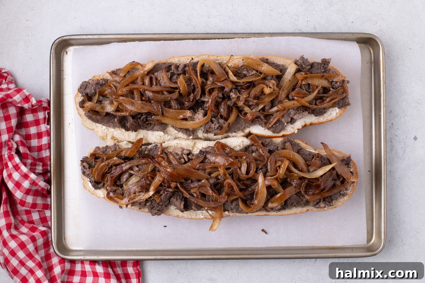 caramelized onions on top of cooked steak and loaf of bread
