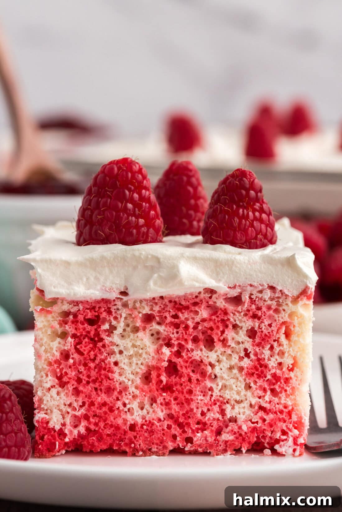 Slice of Raspberry Poke Cake on a plate