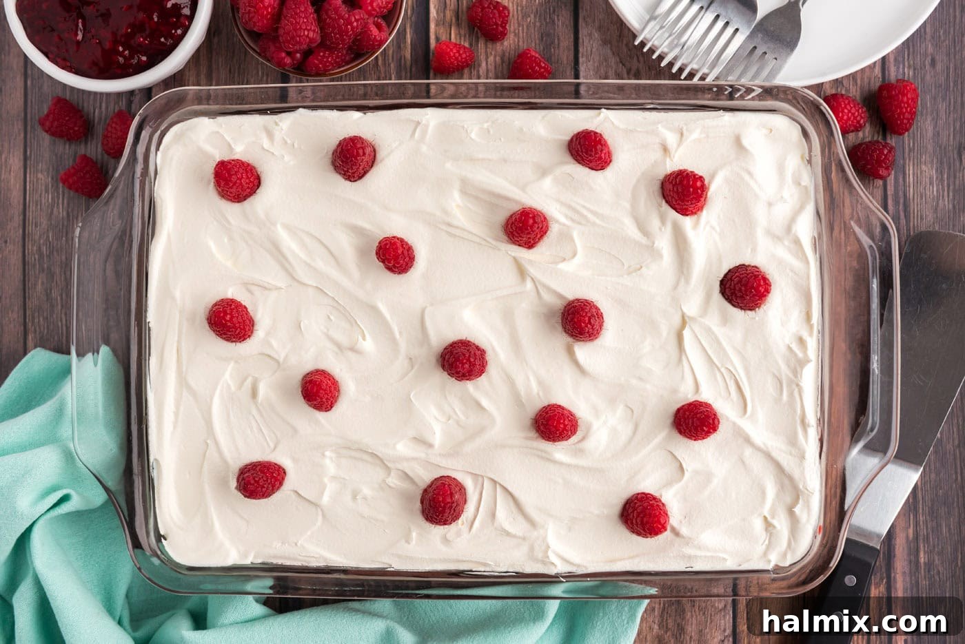 fresh raspberries on top of raspberry cake with cool whip