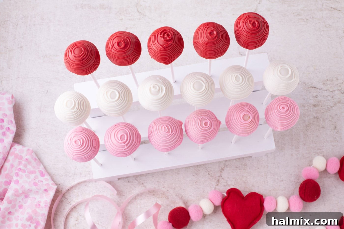 overhead of drizzled cake pops on a stand