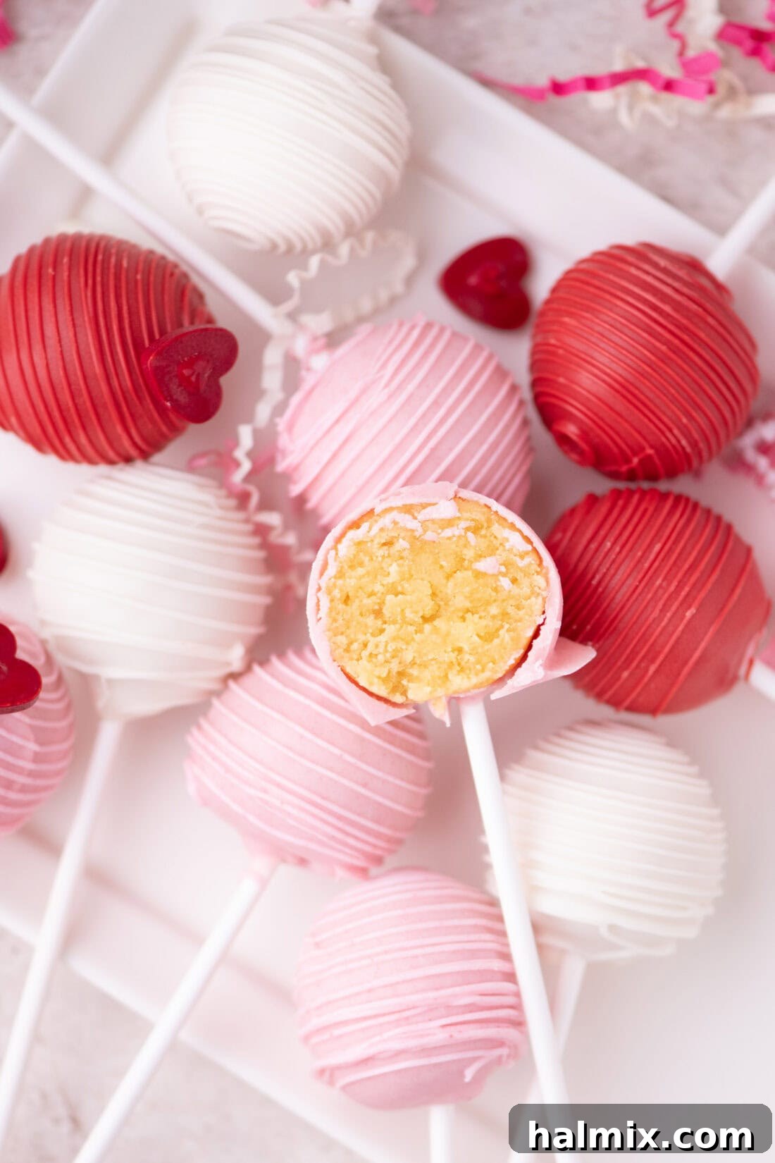 Valentine Cake Pops resting on a plate with one cute in half