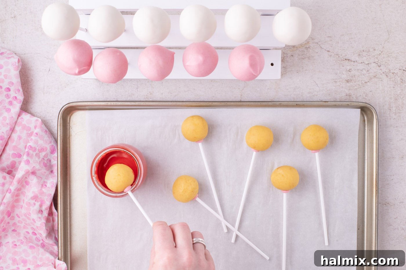dipping cake pop into red chocolate