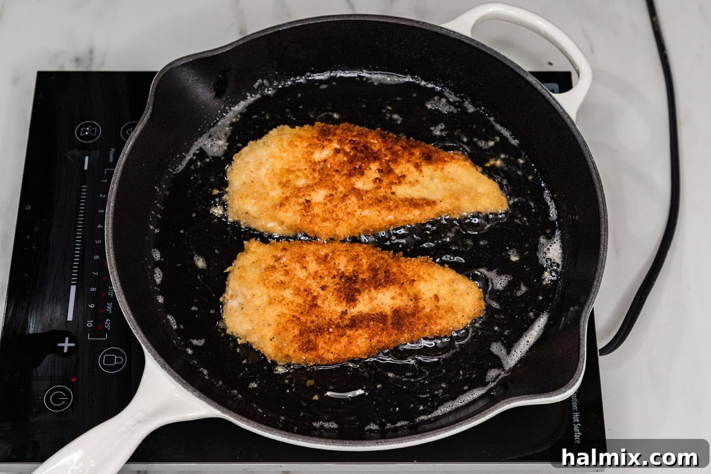 Crispy panko-breaded chicken frying in a skillet of hot oil until golden.
