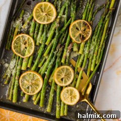 Sheet pan of Lemon Asparagus with a spatula in it, fresh from the oven