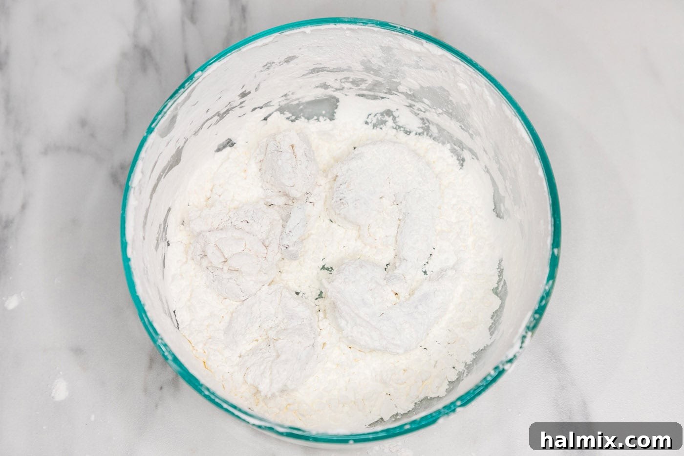Another view of flour-dredged shrimp in a bowl, ready for frying.