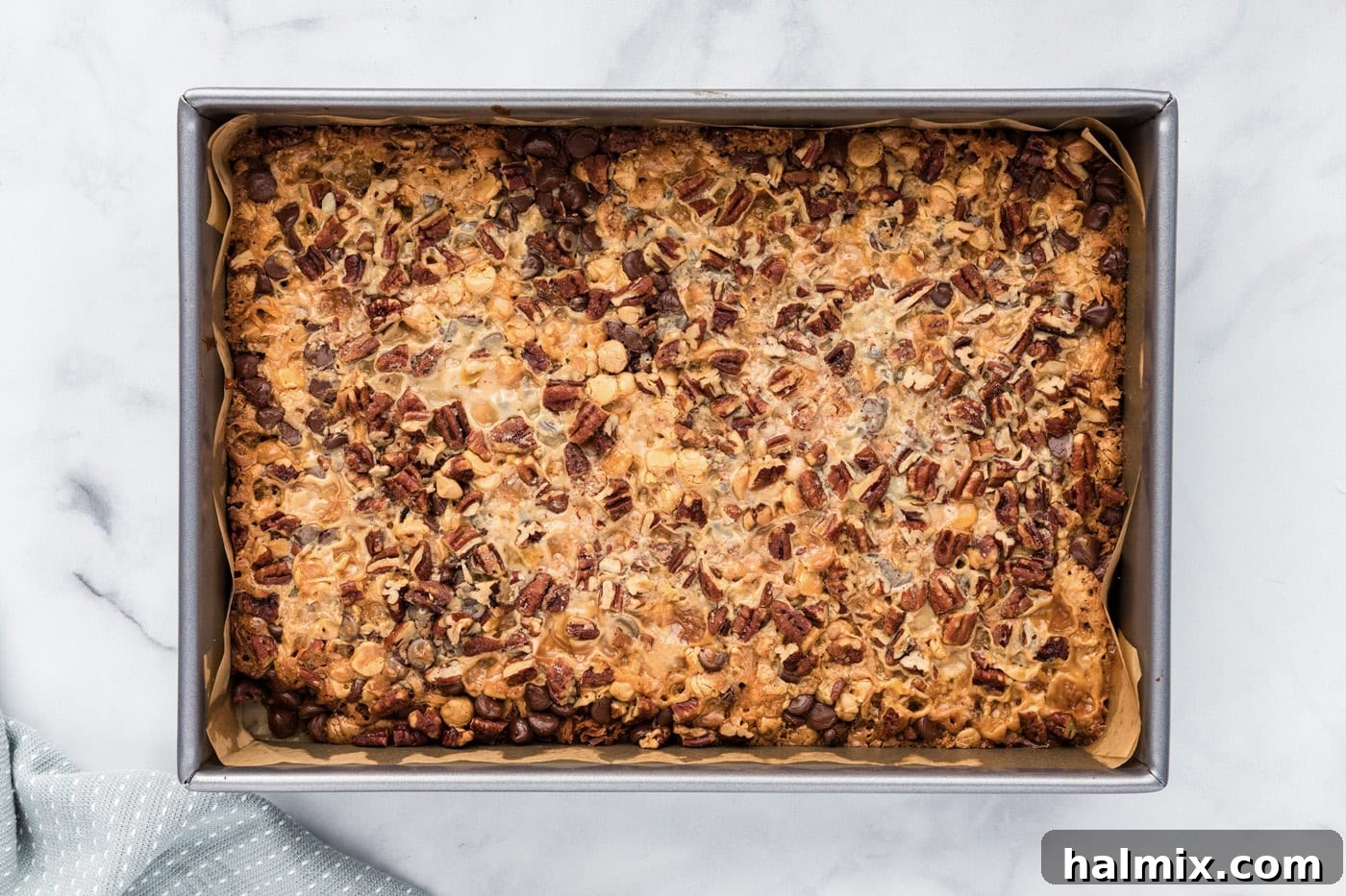 Overhead view of a perfectly baked, golden magic bar in a pan.