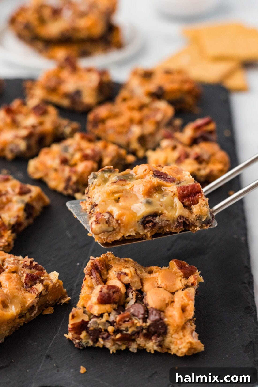 A single Magic Bar being lifted from the pan with a spatula, showing its perfect layers and golden crust.
