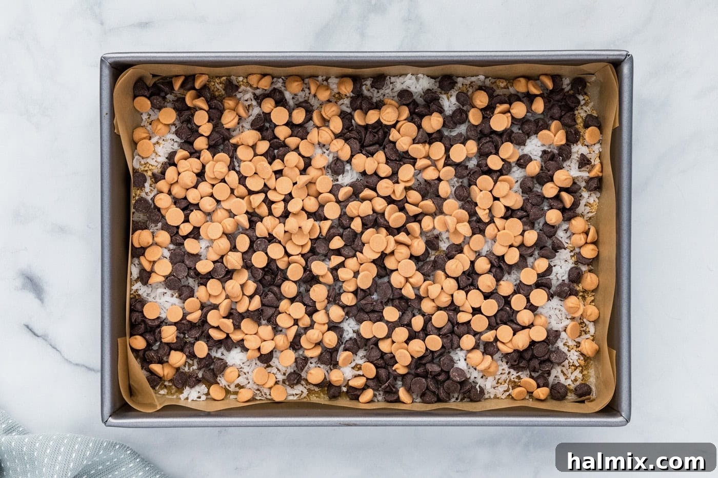 Semi-sweet and butterscotch chocolate chips layered over shredded coconut and butter.