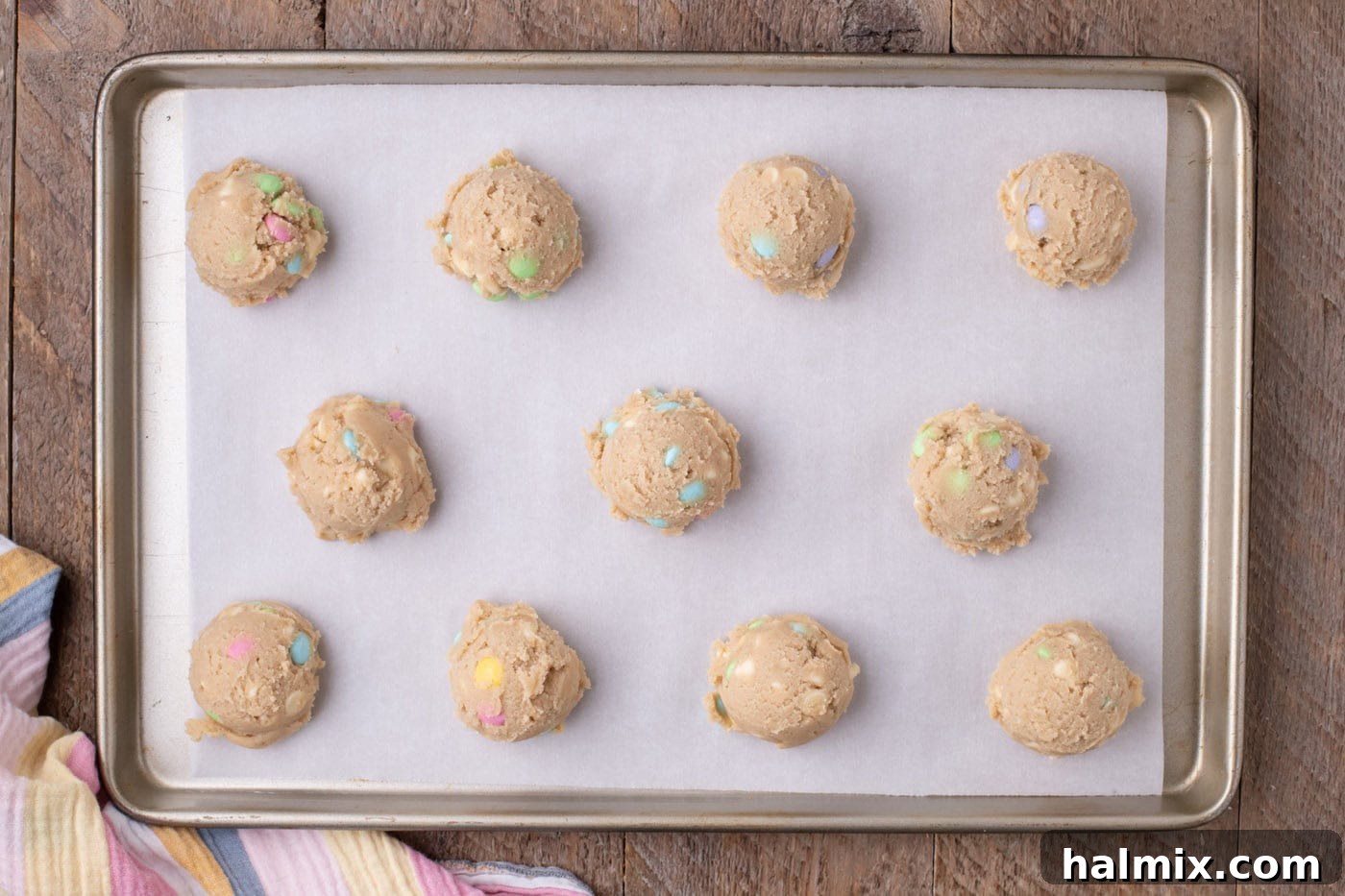 Uniform mounds of cookie dough spaced on a parchment-lined baking sheet, ready for chilling.