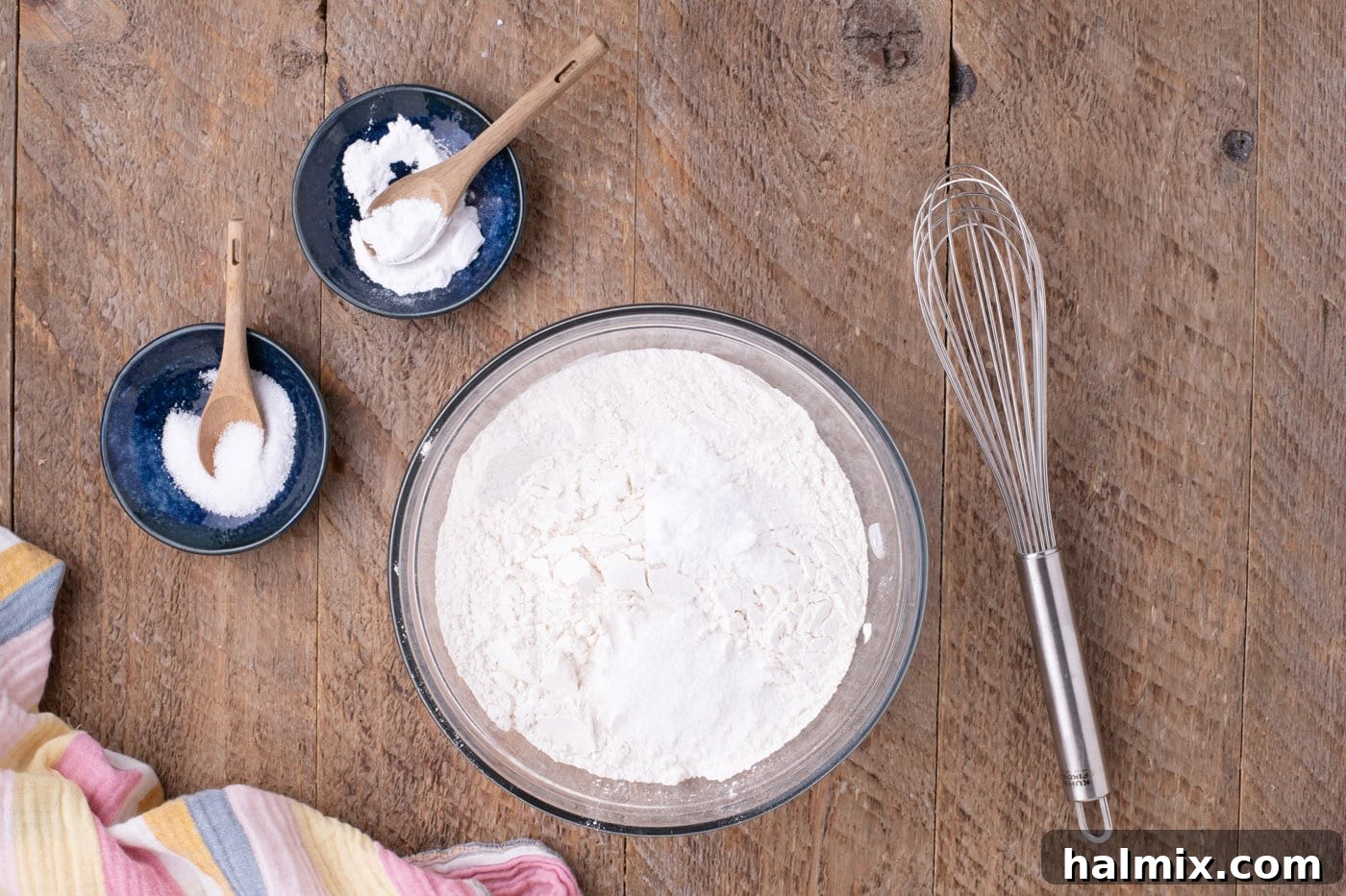 Dry ingredients for cookies (flour, baking soda, salt) whisked together in a bowl.