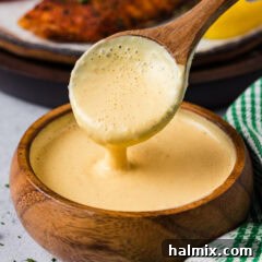 Close up photo of a spoon drizzling Remoulade Sauce into a bowl