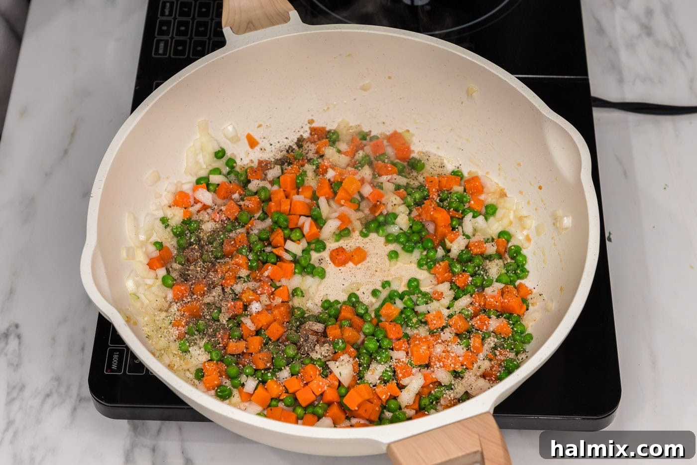 Carrots, peas, and onion in a skillet with oil and garlic, cooking to tender perfection