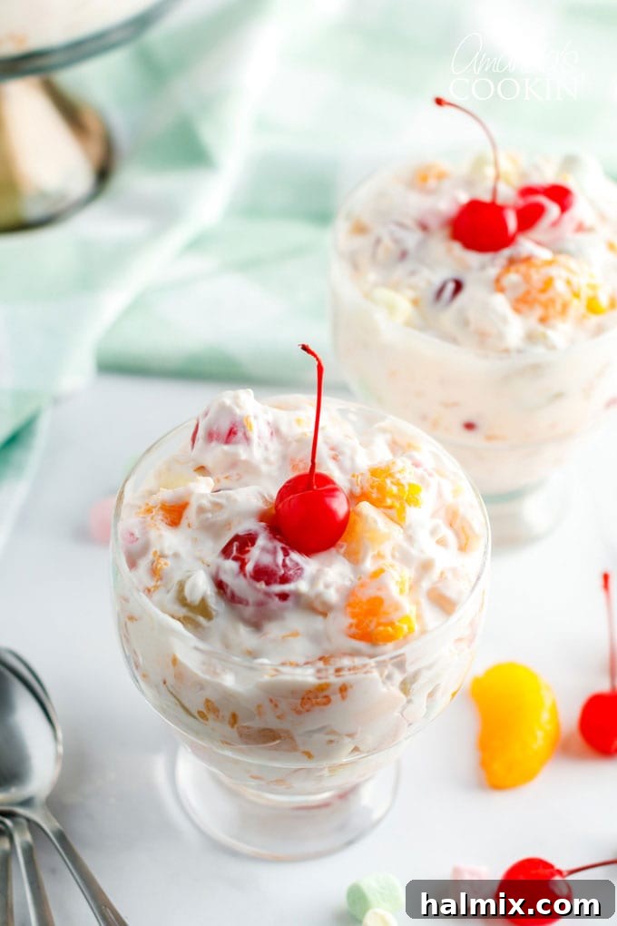 A beautifully presented dessert dish of Ambrosia Salad, showcasing its vibrant fruits and fluffy texture.