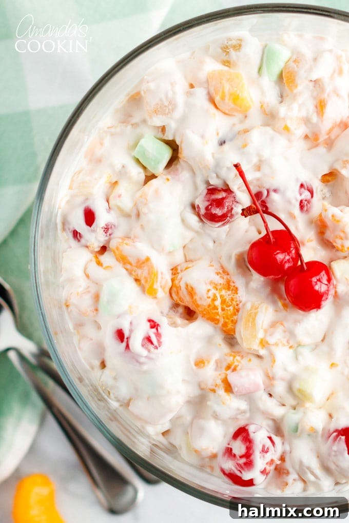 A close-up view of a large bowl filled with fluffy, colorful Ambrosia Salad, highlighting its inviting texture and ingredients.