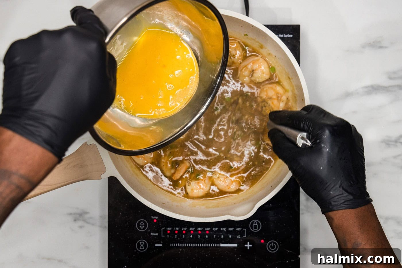 whisking egg mixture into skillet with shrimp