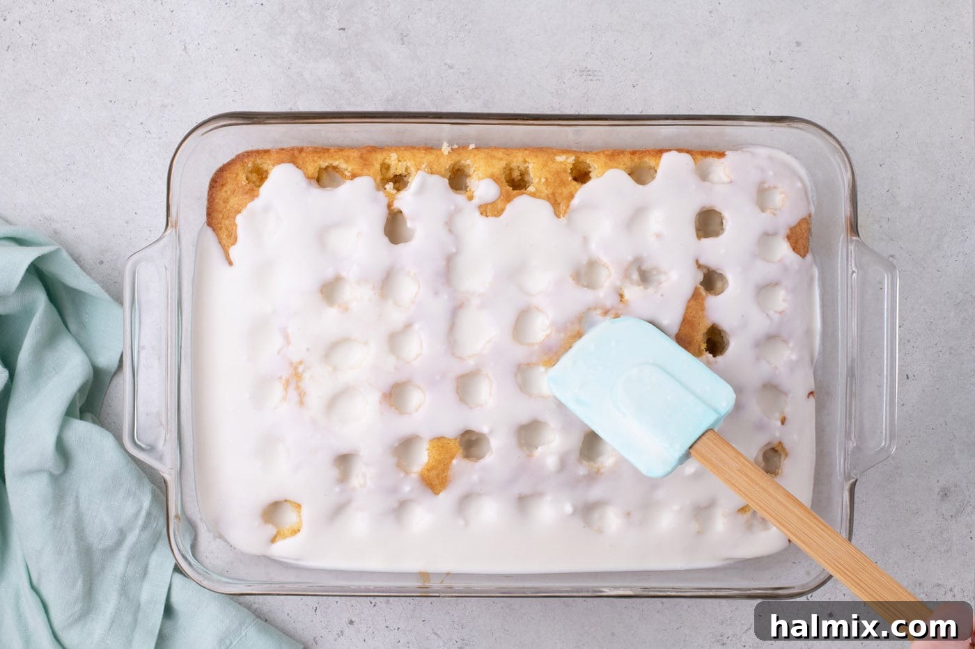 spreading coconut cream filling over holes in a cake