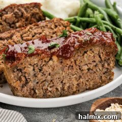Close up photo of a slice of Quaker Oats Meatloaf on a plate, garnished with parsley.