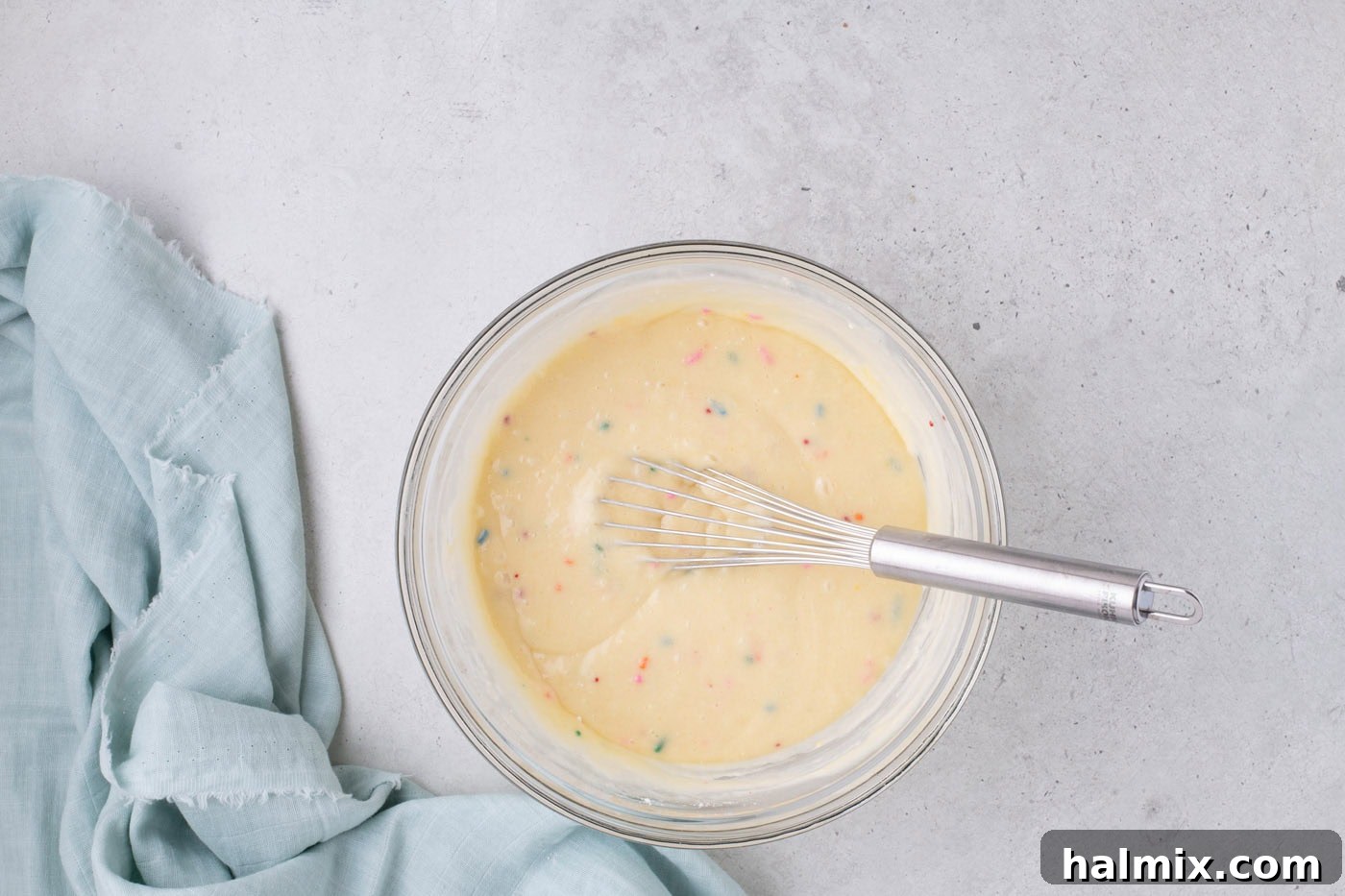 Cake mix in a bowl with a whisk, showing the initial mixing step.