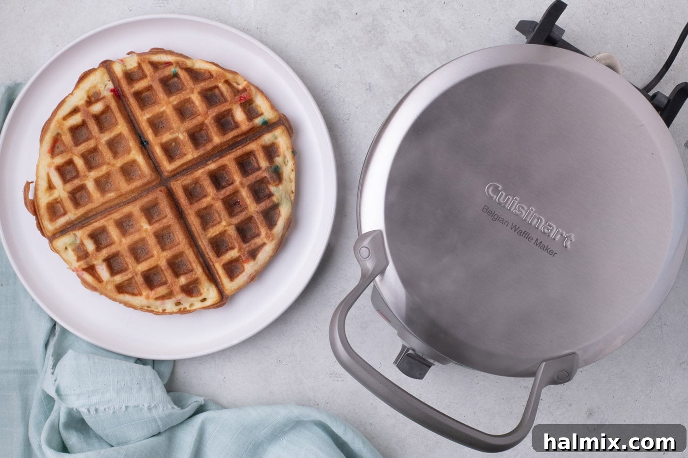 Freshly cooked cake mix waffles on a plate, showing their golden color.