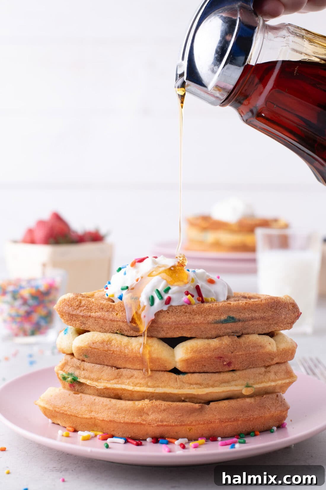Syrup being poured generously onto a stack of freshly made Cake Mix Waffles.