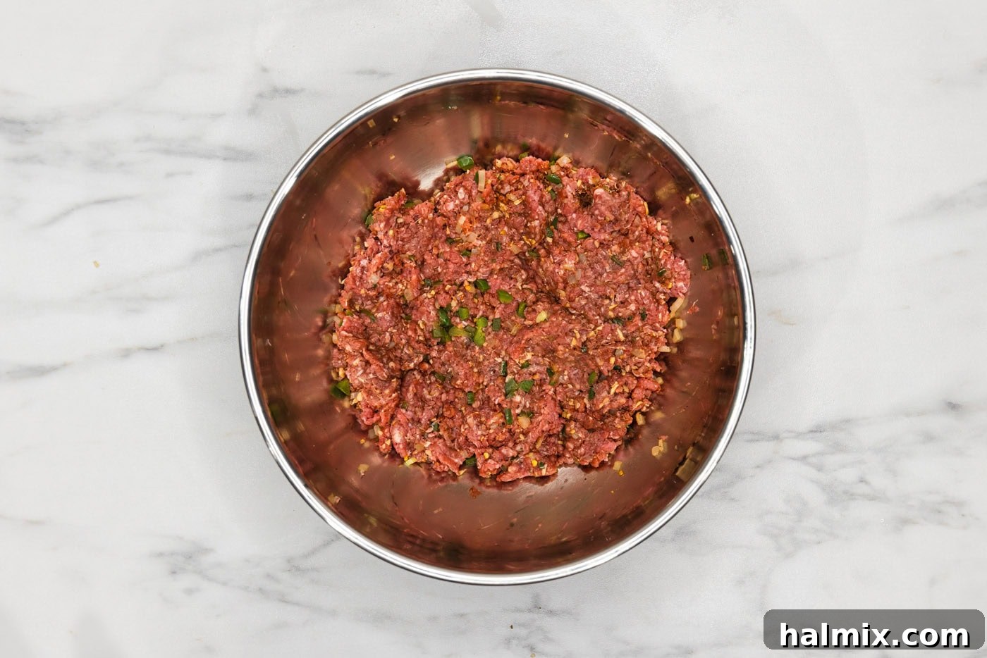Fiesta Burger 6 Ground beef mixed with diced jalapeños, onions, and taco seasoning in a large bowl, ready for patty formation.