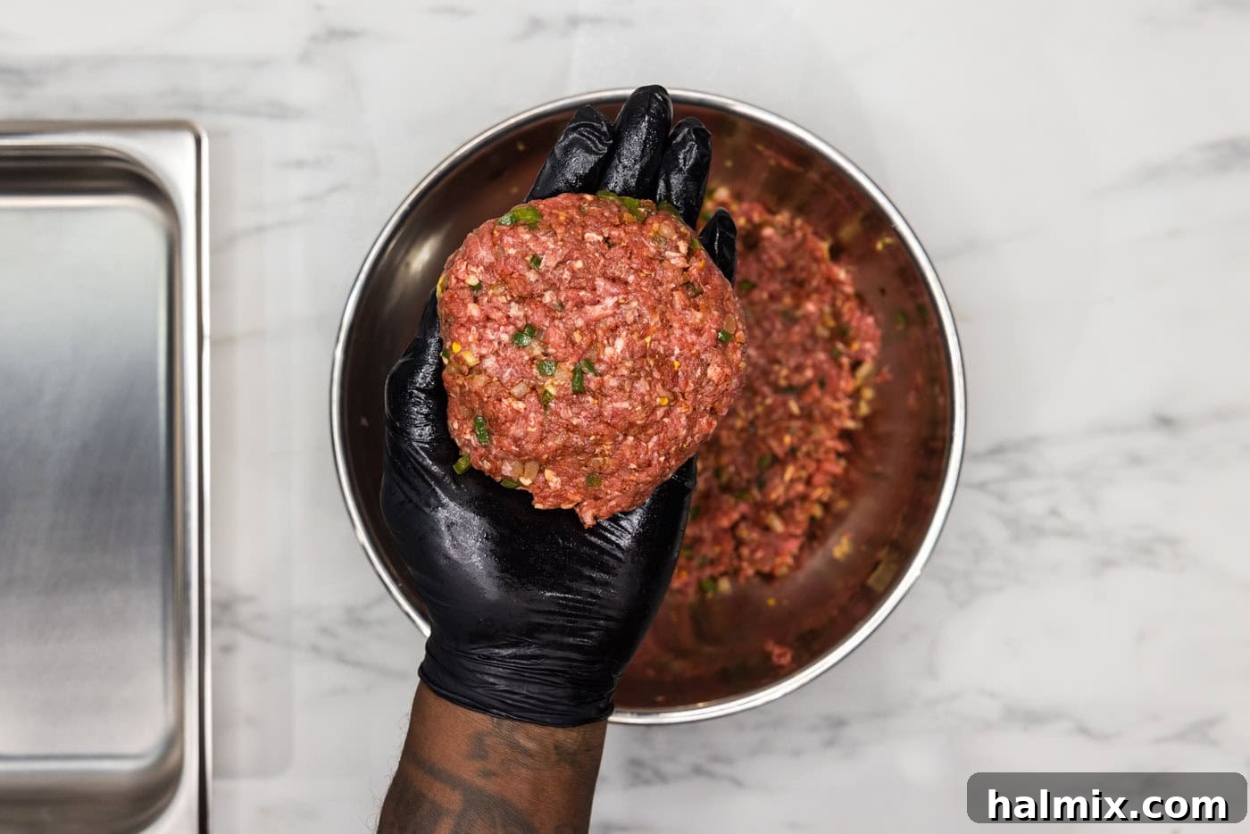 Fiesta Burger 7 A gloved hand gently forming a burger patty, showing the ideal shape and thickness with a thumbprint indentation in the center.