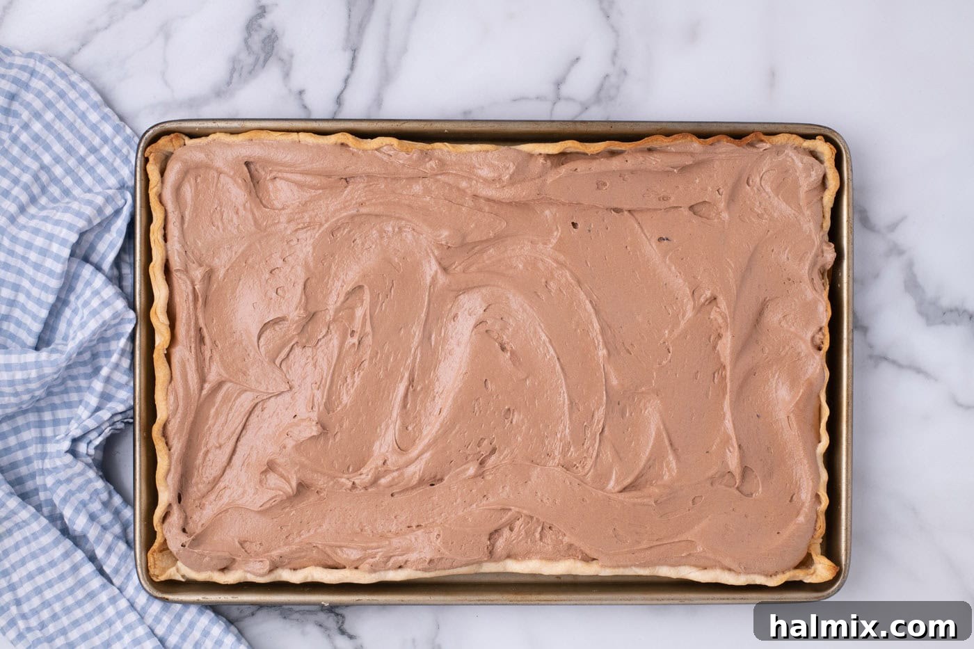 Smooth, rich French silk pie filling spread evenly into the cooled pie crust in a jelly roll pan, chilling in the refrigerator.