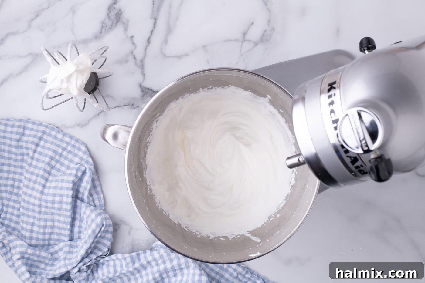 Freshly made homemade whipped cream in a stand mixer bowl, perfectly stiff and ready to be spread.