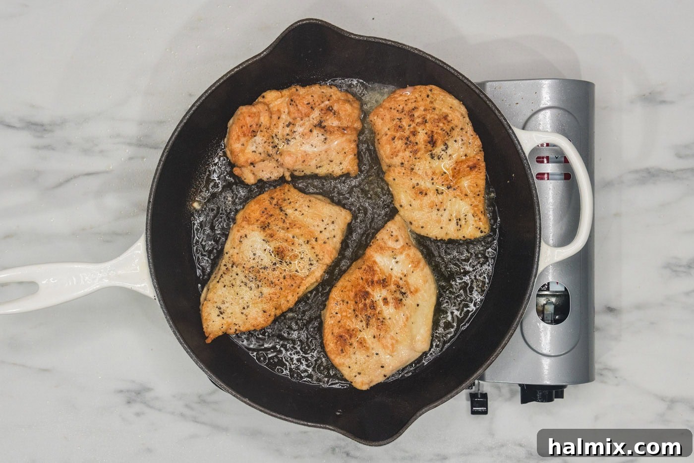 Tropical Coconut Chicken 8 Perfectly seared chicken breasts, golden-brown on both sides, in a skillet.