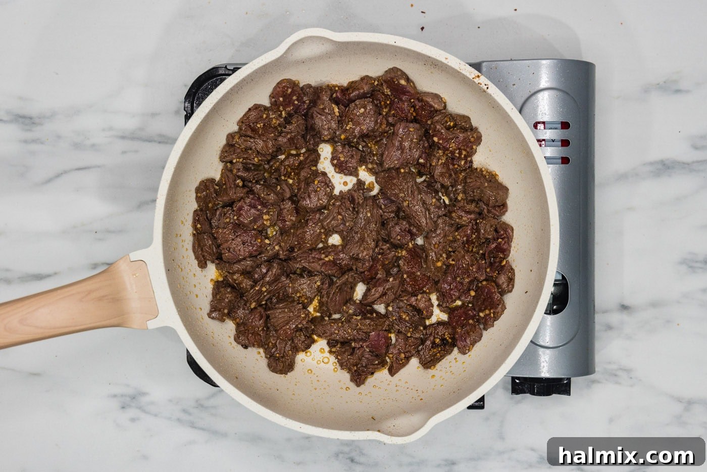 sliced steak and seasonings in a skillet