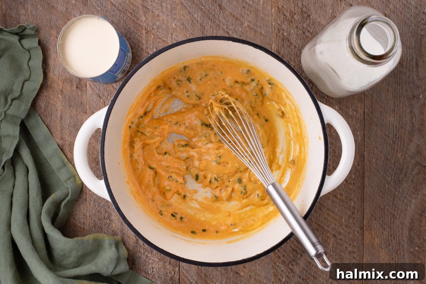 Kicking Cheesy Jalapeño Mac 6 whisking evaporated milk into jalapeno mixture in a pot