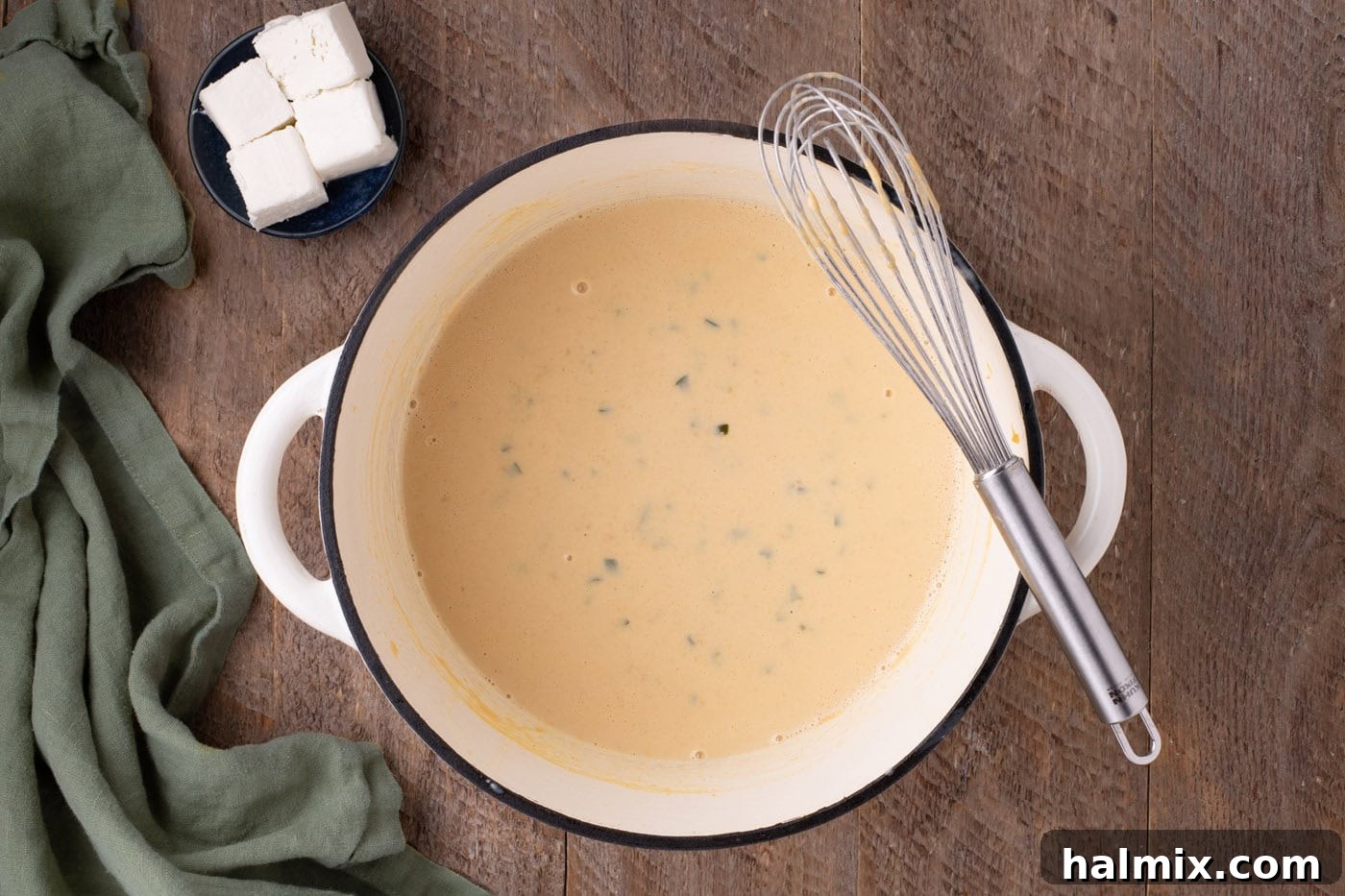 Kicking Cheesy Jalapeño Mac 8 jalapeno cheese sauce in a pan with a whisk