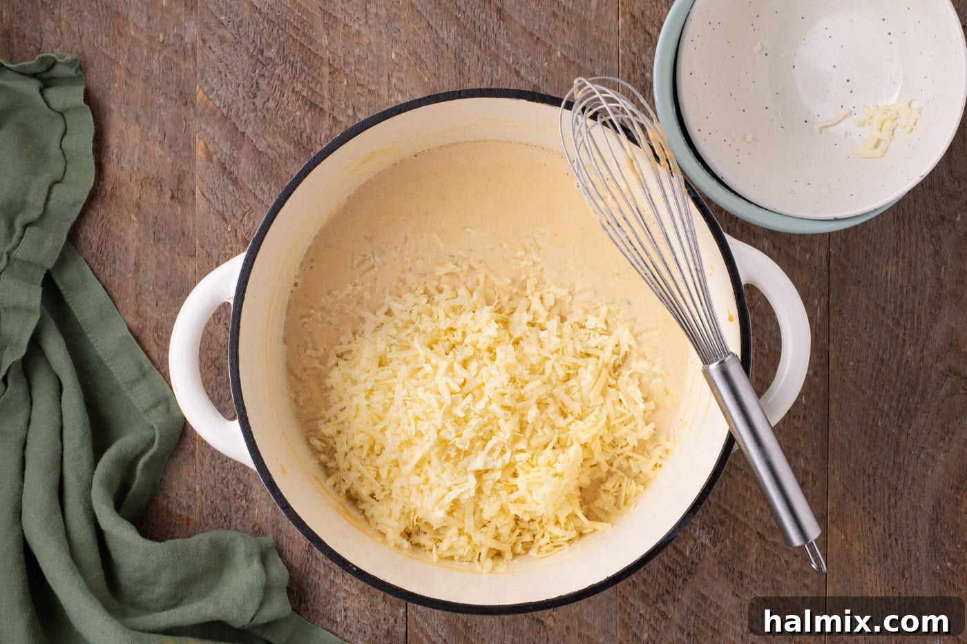 Kicking Cheesy Jalapeño Mac 9 cheese added to jalapeno mixture in a pot