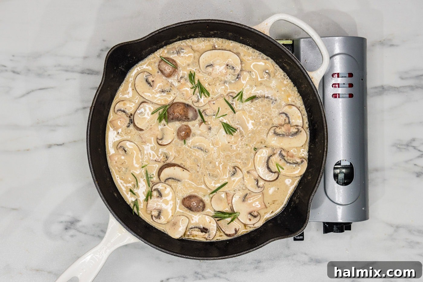 creamy scallopini sauce in a skillet with mushrooms, showing the sauce thickened and mushrooms tender.