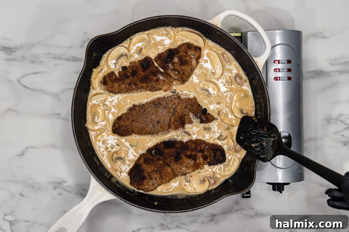 veal cutlets in cream and mushroom sauce in a skillet, ready to be served.