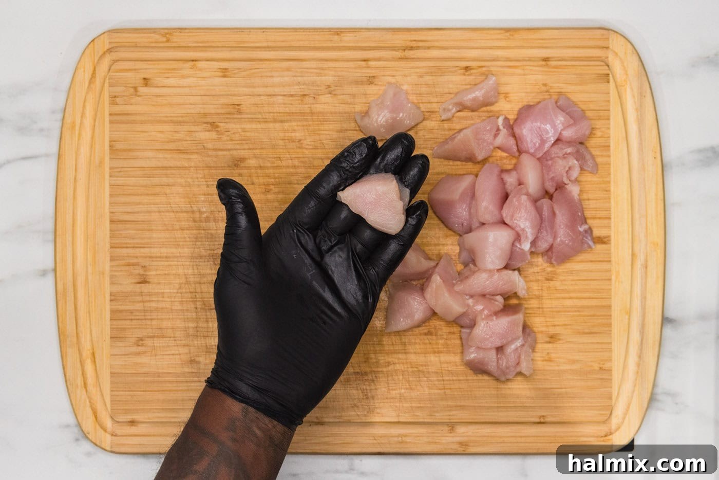 hand holding cubed chicken breast