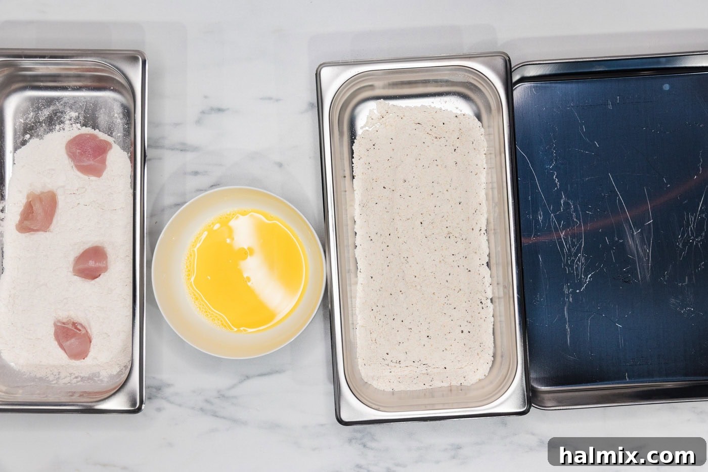 chicken in a breading tray with flour