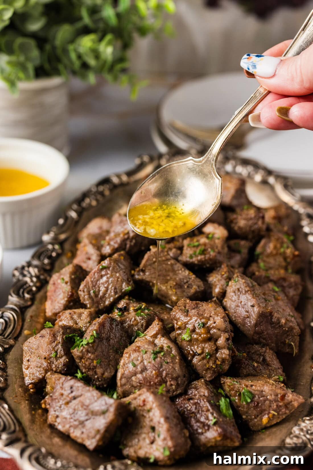 Garlic butter being drizzled over Air Fryer Steak Bites