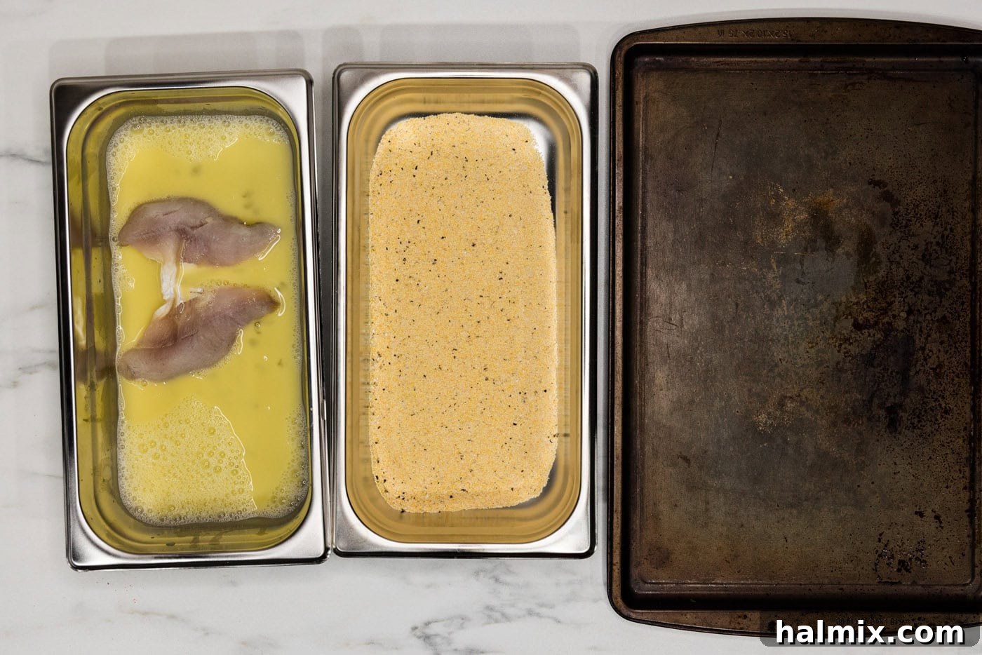 perch filets in egg mixture in a breading tray